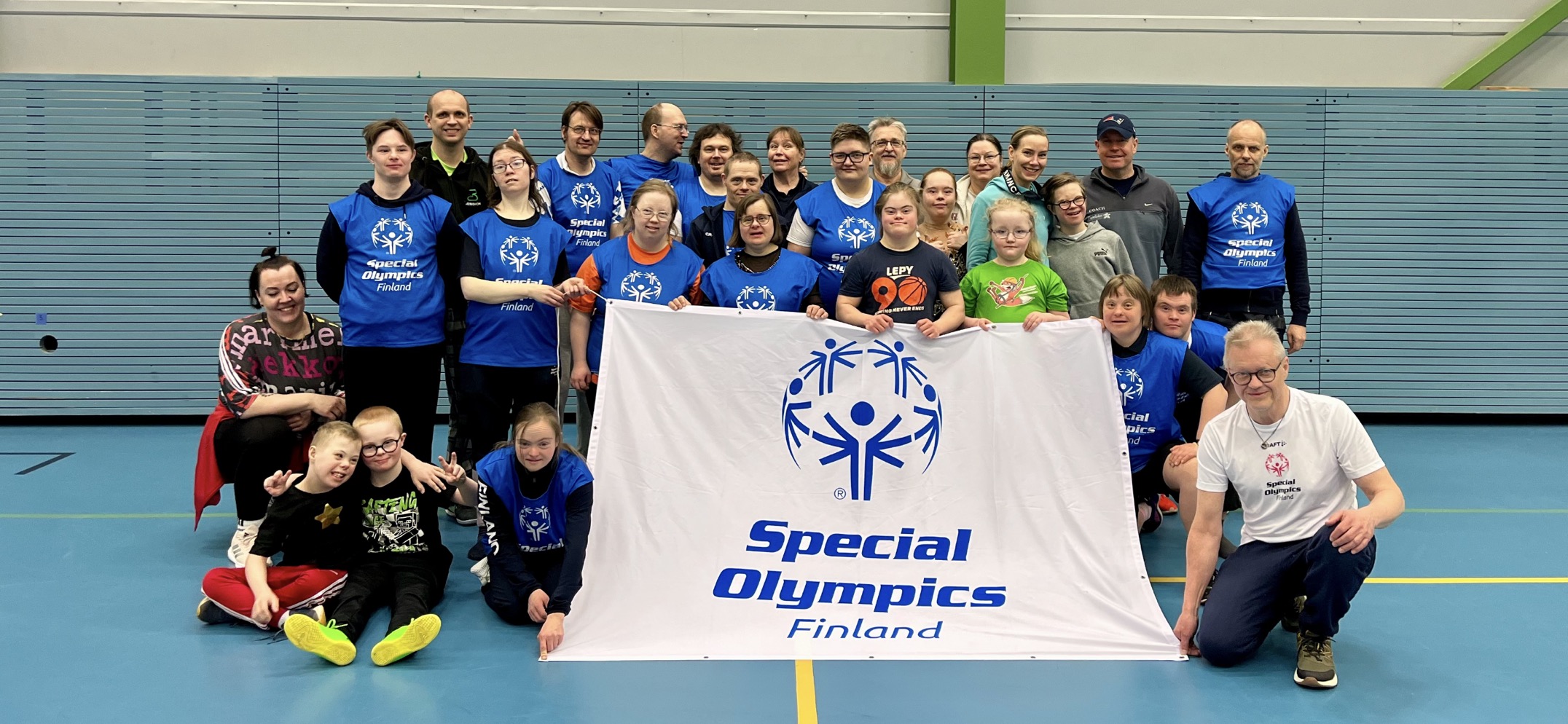 Iloinen Athlete Leader -porukka yhteiskuvassa SO-lipun kanssa.